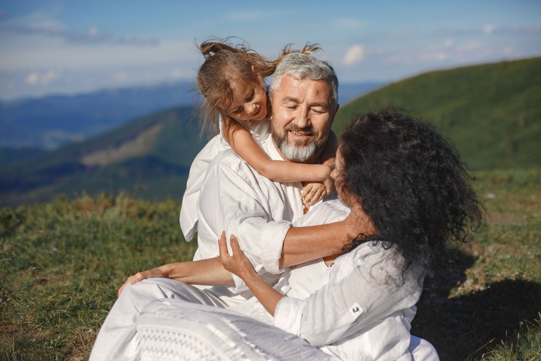 Grandparents playing outdoors with their granddaughter